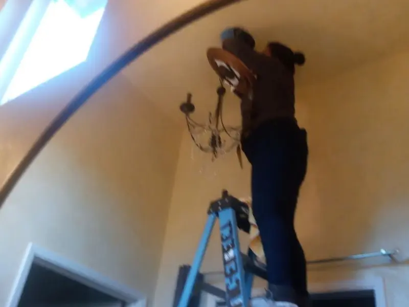 Electrician installing a chandelier in a Vinings residence